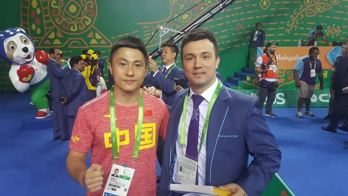 Daniel Flash with an athlete in a red China shirt at an international event