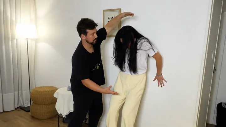Dr. Daniel Flash guiding a standing client against the wall during a Crane session