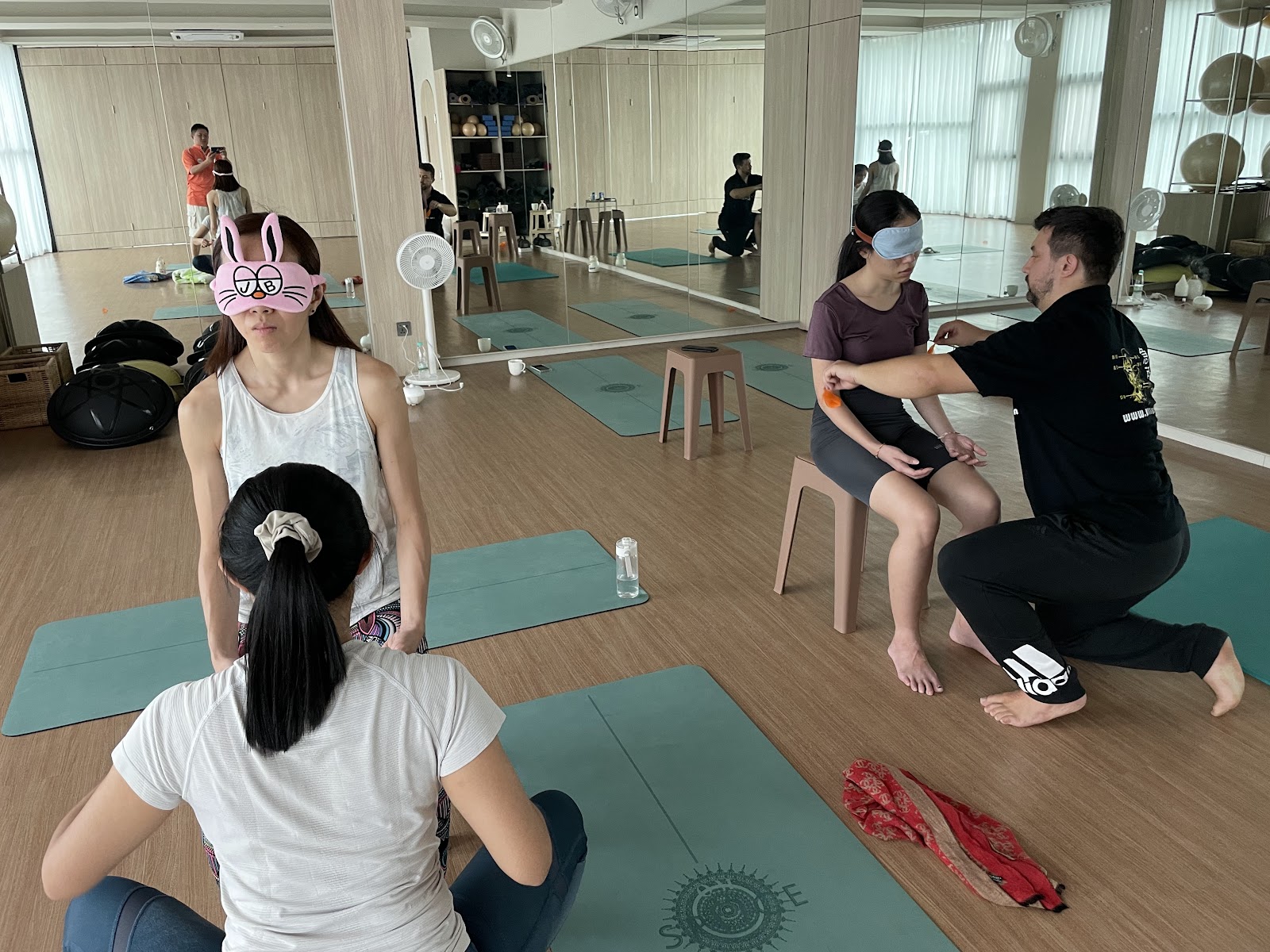 Dr. Daniel Flash guiding partner work with seated students at Om Space, Malaysia