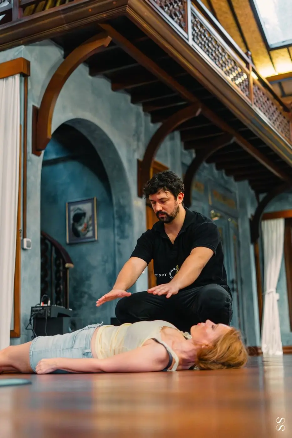 Dr. Daniel Flash working hands-on with a client lying on the floor