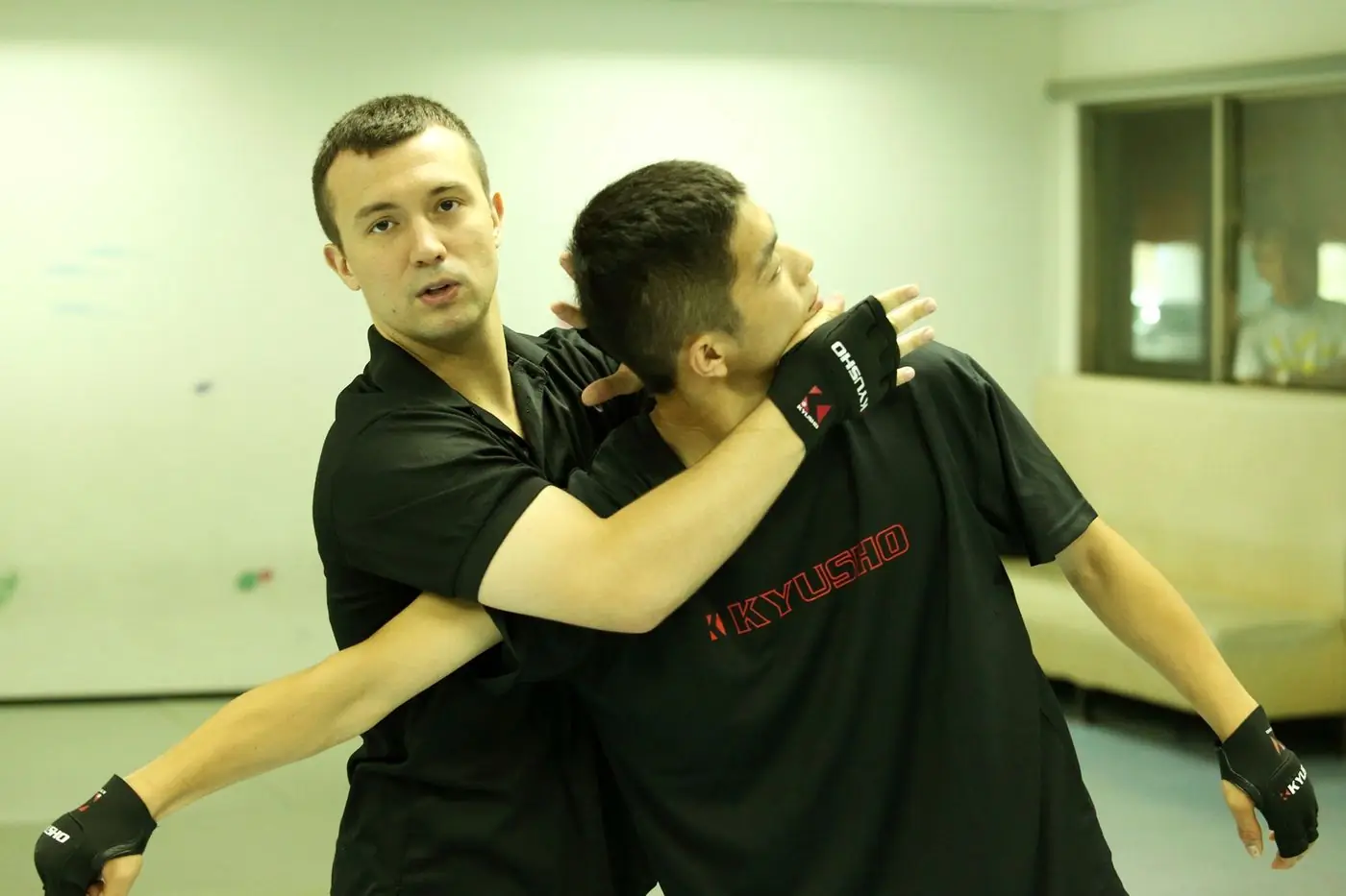 Daniel Flash applying a Kyusho technique to a partner under a Kyusho Taiwan banner