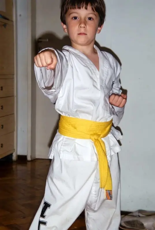 Daniel Flash as a young boy in a white martial arts uniform with a yellow belt