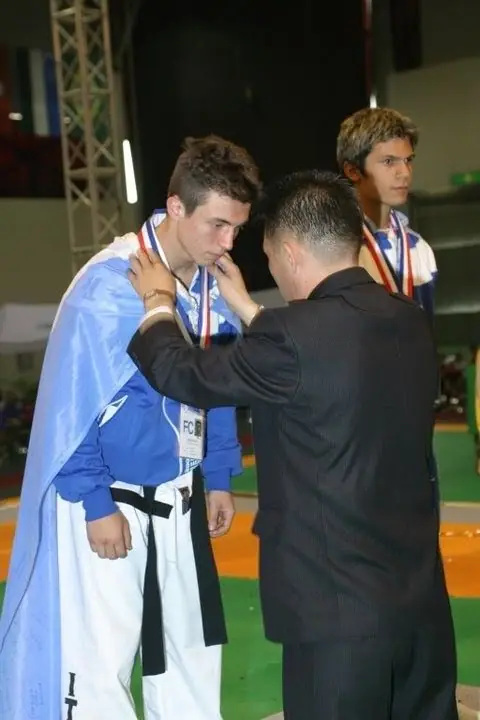 Teenage Daniel Flash wrapped in the Argentine flag receiving a medal
