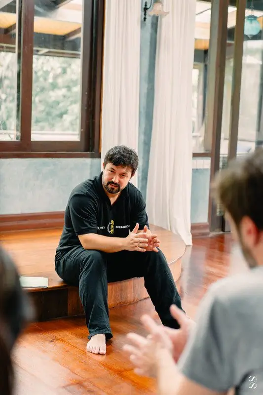 Dr. Daniel Flash seated, teaching a group