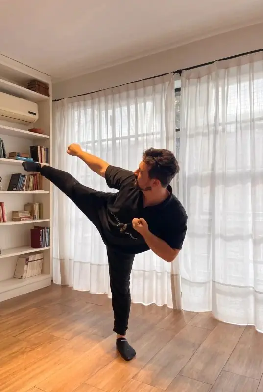 Dr. Daniel Flash performing a high side kick in a studio