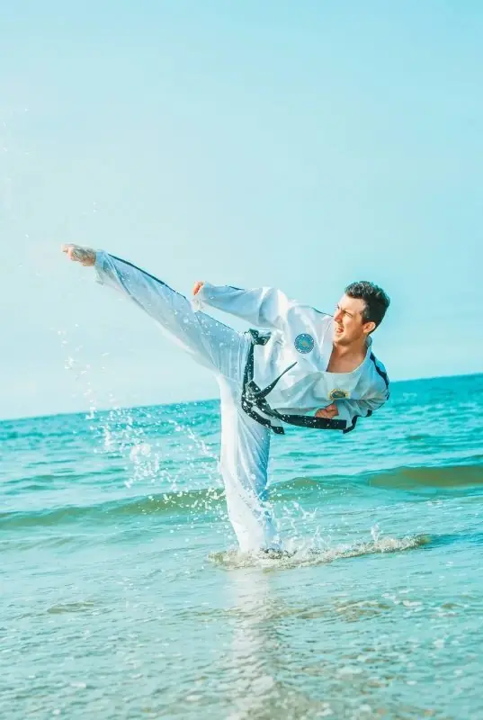 Daniel Flash performing a high flying kick on the beach