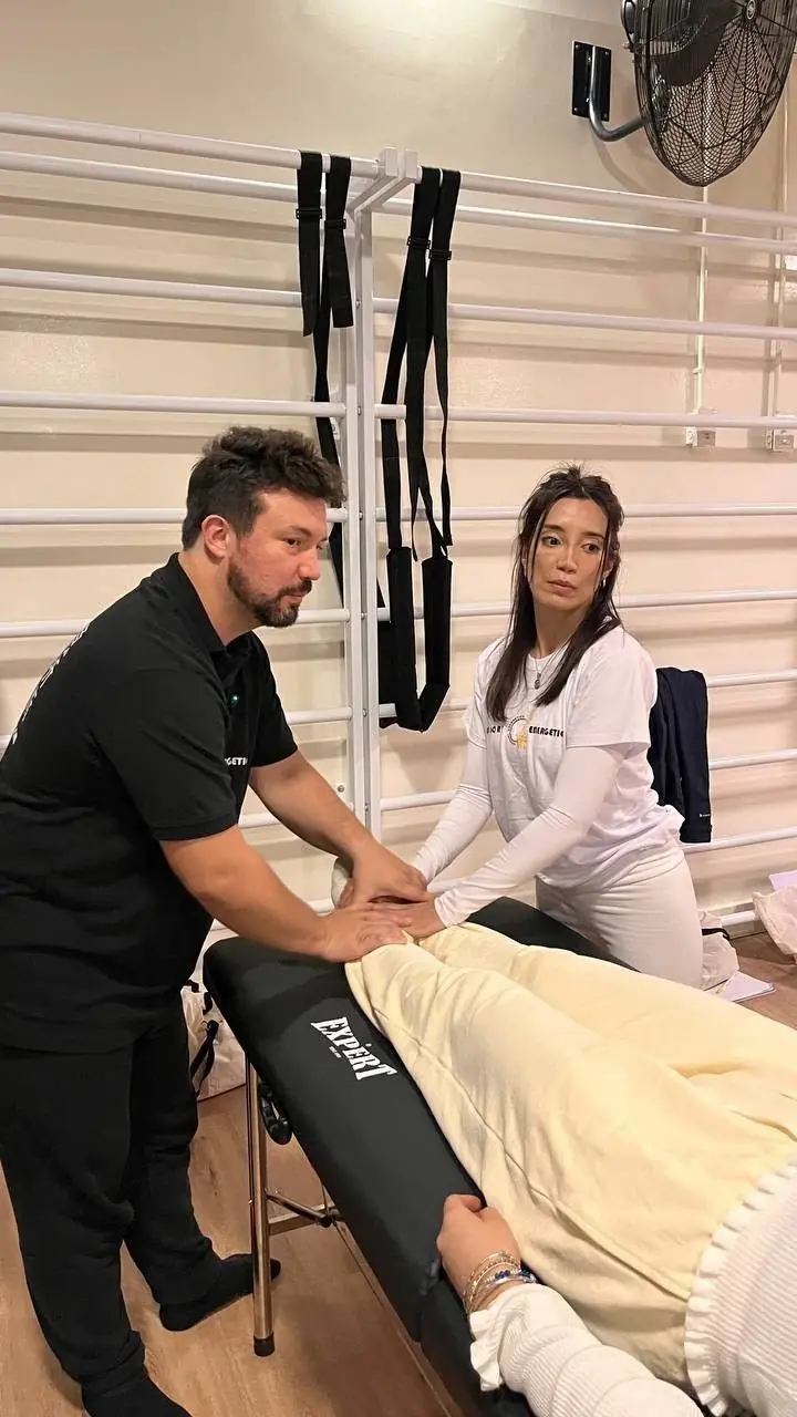 Dr. Daniel Flash treating a client on a table with an assistant