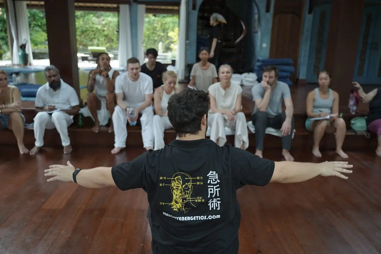 Dr. Daniel Flash opening a seminar with arms wide in front of seated students